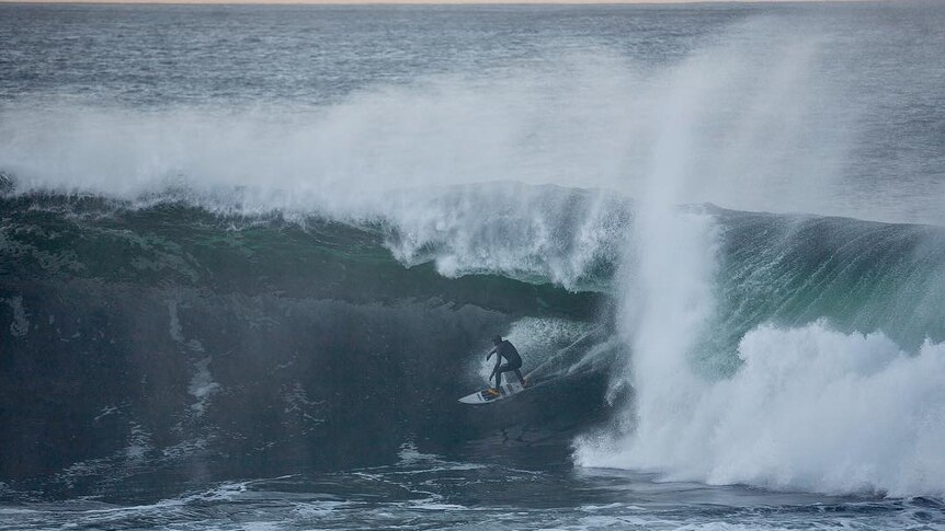A surfer rides a big wave.