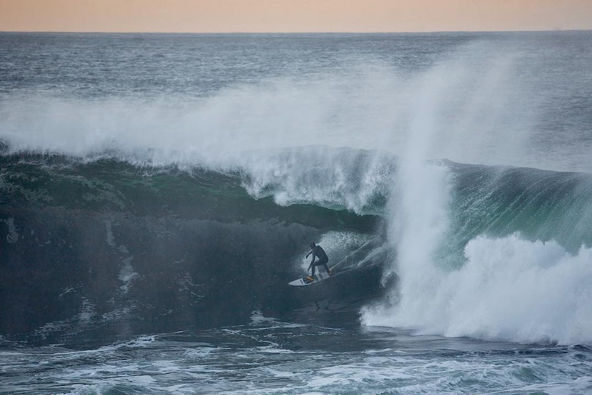 A surfer rides a big wave.