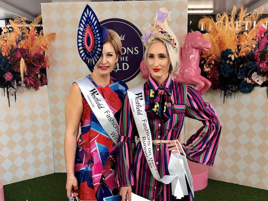 Women in hats and colourful dresses who won a Melbourne Cup fashion contest at Doomben racecourse