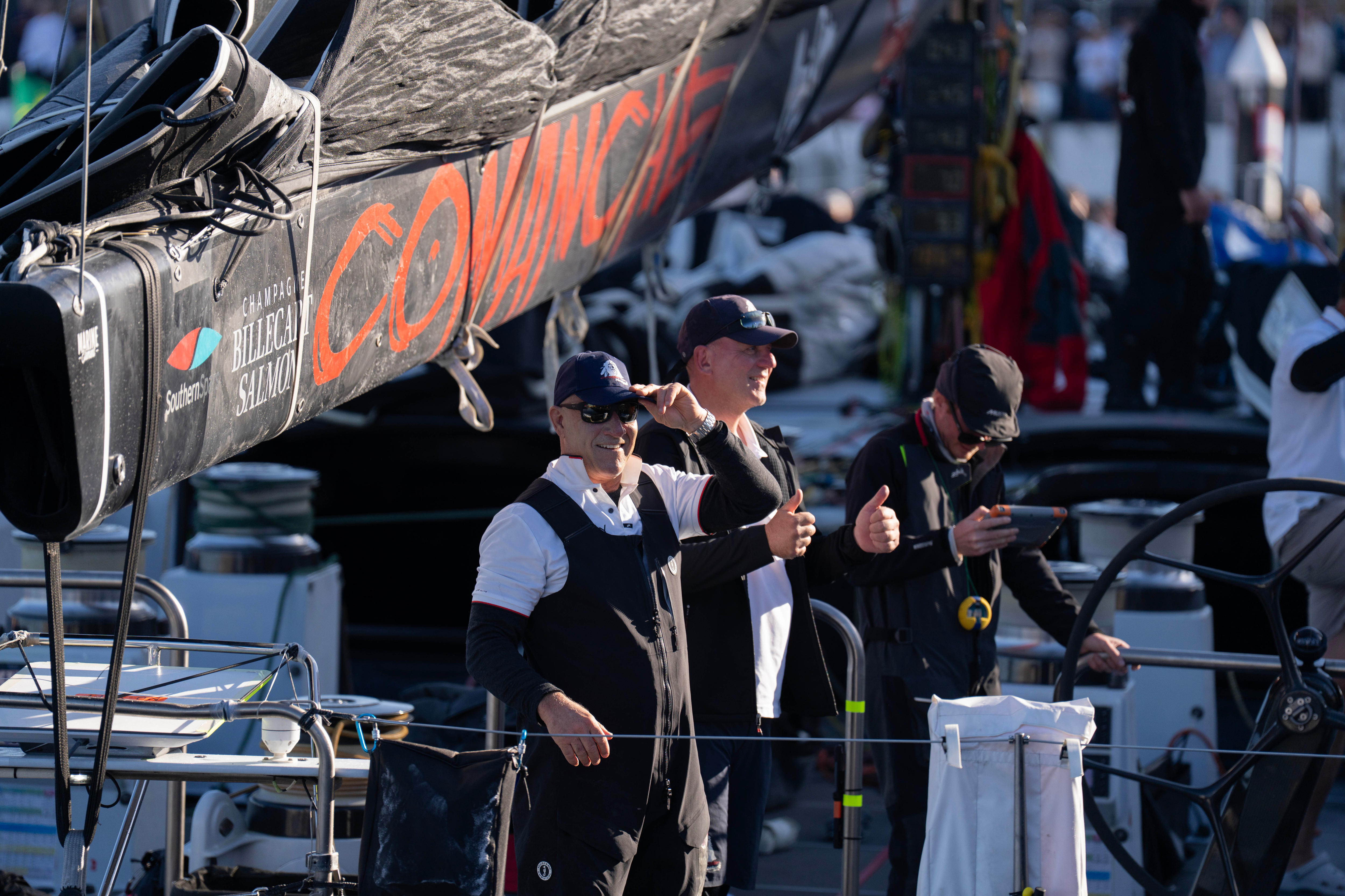 Dos hombres en un barco sonríen y levantan el pulgar