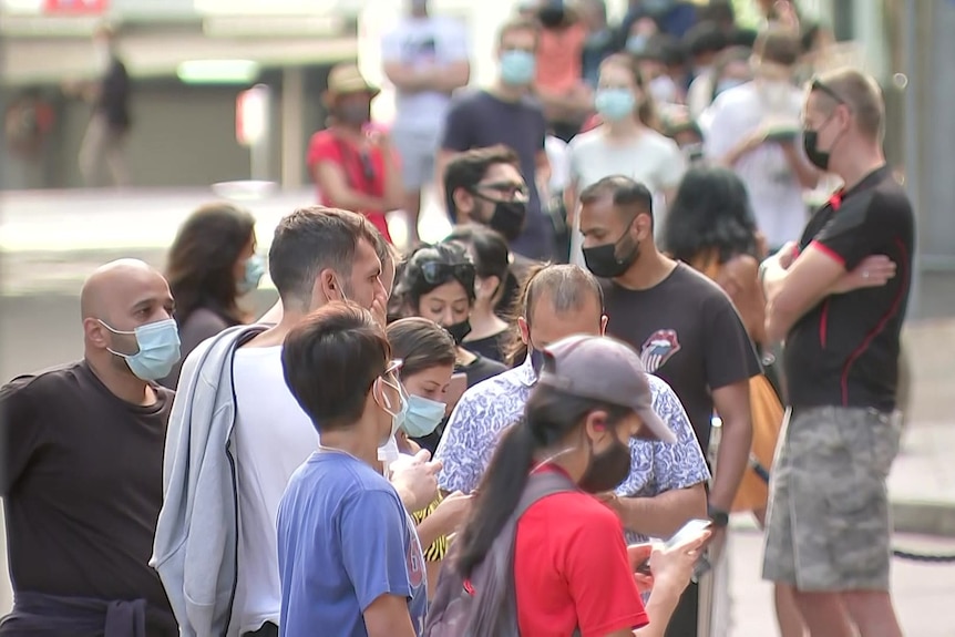 people in queue lining up outside a covid testing clinic