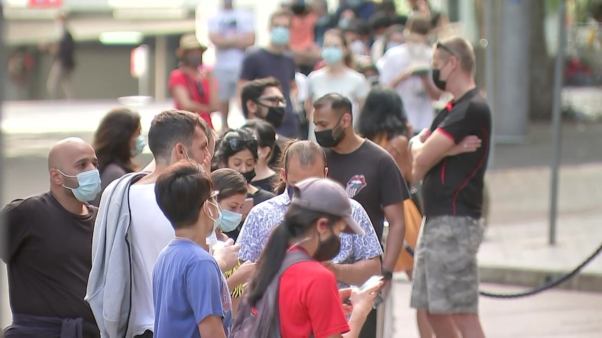 people in queue lining up outside a covid testing clinic