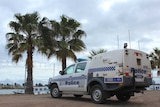 A police car parked near Bunbury Yacht Club with palm trees in the background.