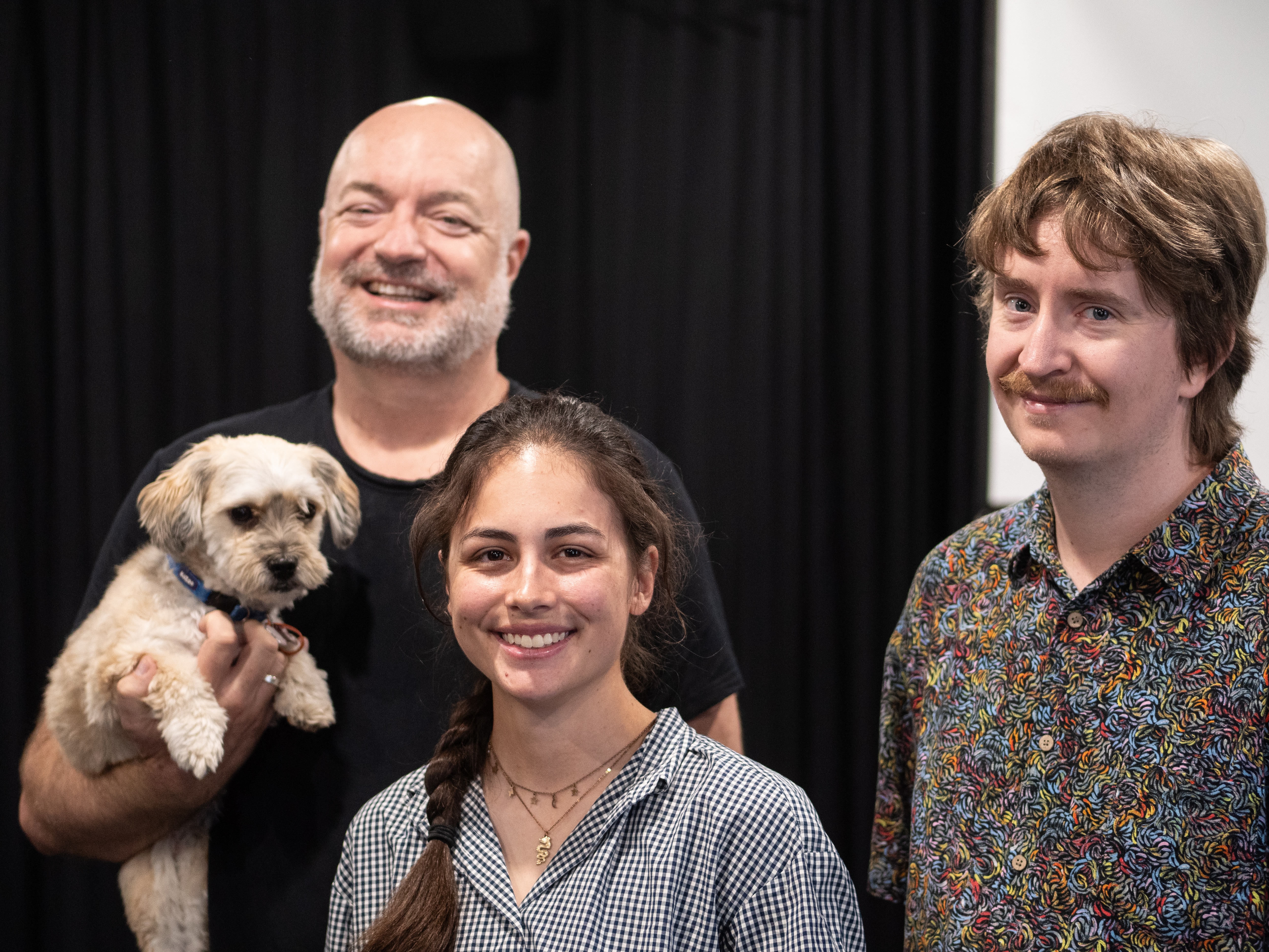 Older man, young woman and young man look at camera, all smiling