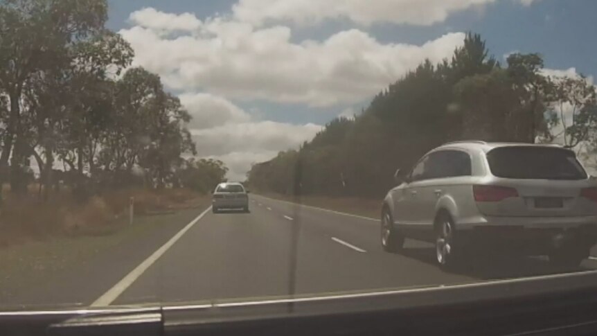 An SUV overtaking a car on the right side of the road.