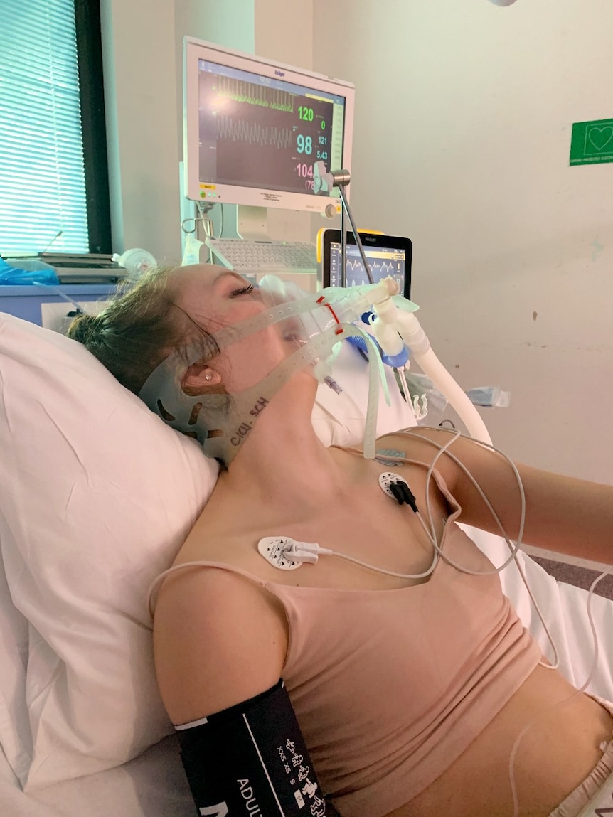 Dakota Stephenson lying in a hospital bed with an oxygen mask covering most of her face.