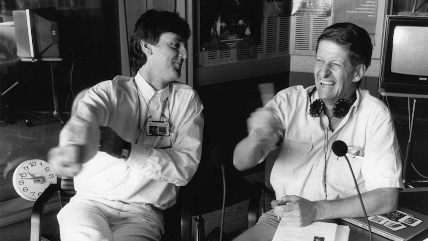 A black and white photograph of Roy and HG smiling in the radio studio