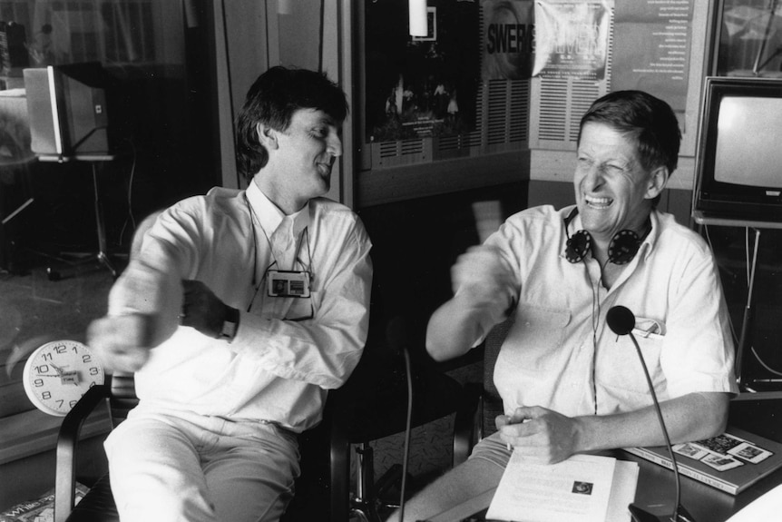 A black and white photograph of Roy and HG smiling in the radio studio