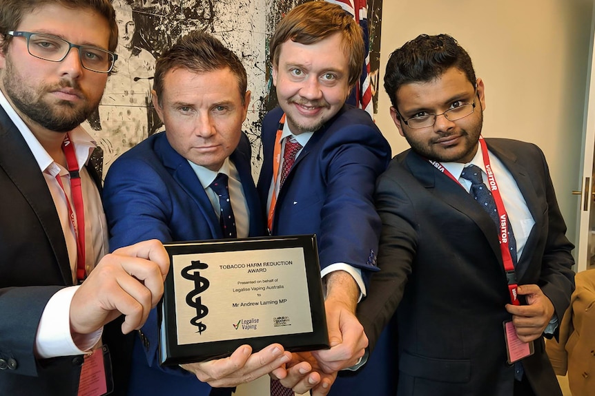 Andrew Laming MP poses with an award from three vaping activists.