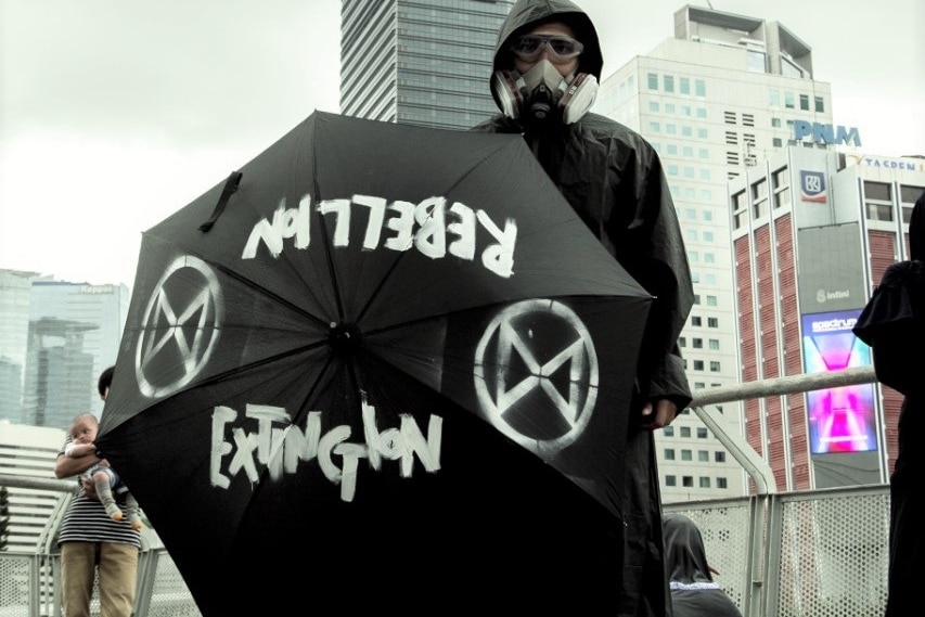 A man holding an umbrella in the middle of a street.