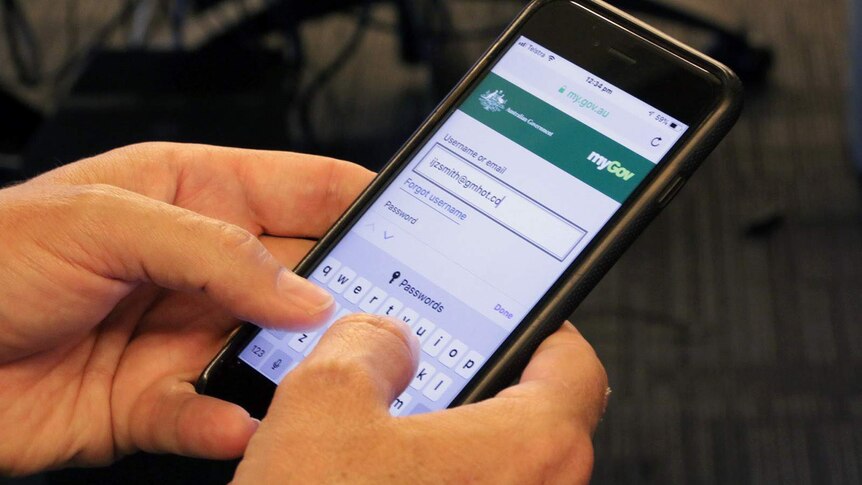A man tries to log in to myGov on a mobile phone.