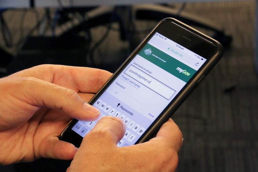 A man tries to log in to myGov on a mobile phone.