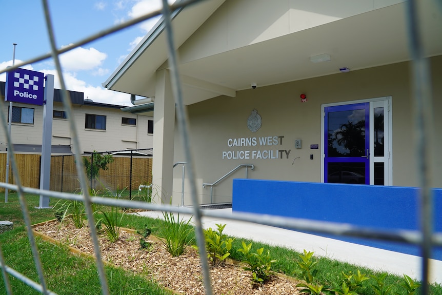 A grey building with police sign and 'Cairns West Police Facility' on the outside