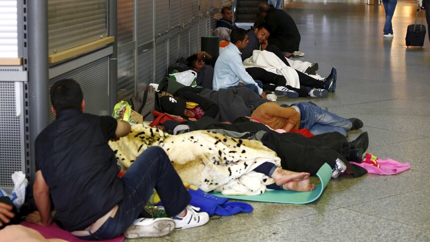 Migrants sleep in the hall of the main railway station in Munich
