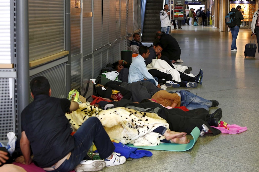 Migrants sleep in the hall of the main railway station in Munich