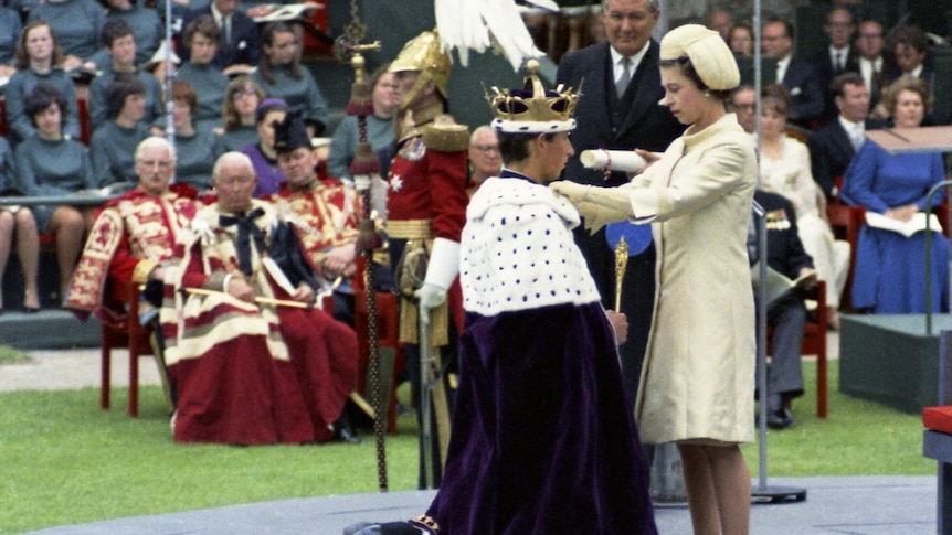 Prince Charles kneels before his mother Queen Eizabeth II during the investiture ceremony at Caernafon Castle.