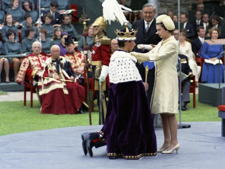 Prince Charles kneels before his mother Queen Eizabeth II during the investiture ceremony at Caernafon Castle.