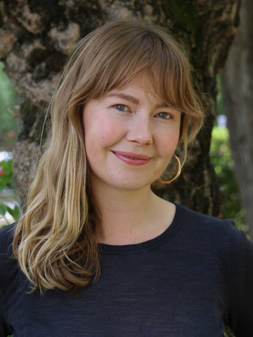 Lily Dempster standing in front of a tree