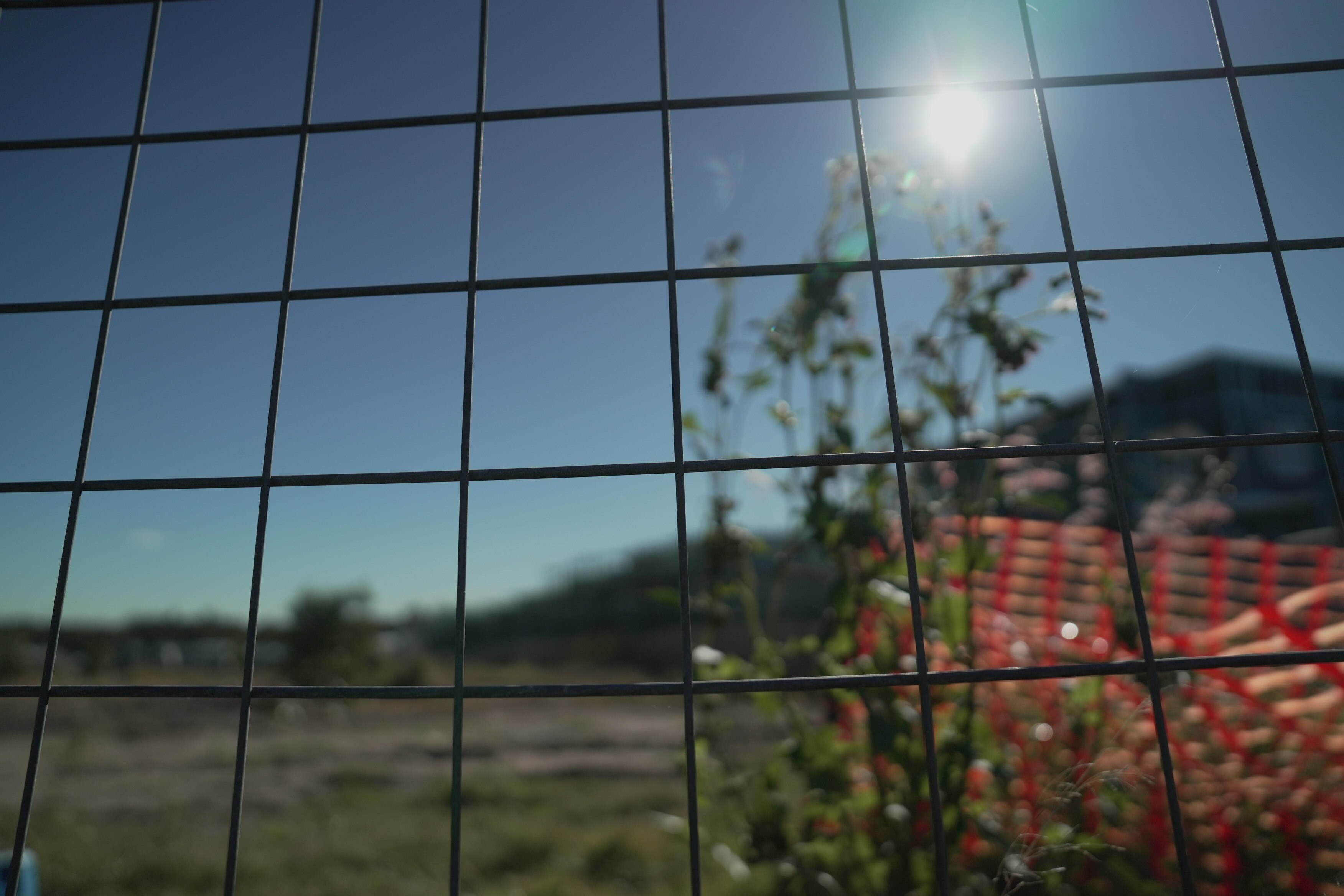 Sun shines through a fence at a building site in Rochedale.