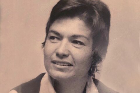A black and white photo of a woman with close cropped hair with a slight smile on her face