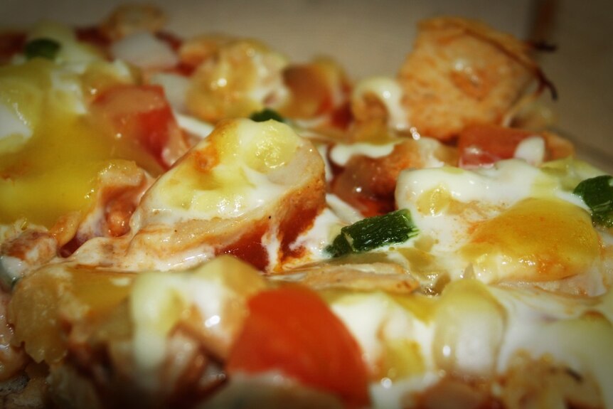 Close up photo of pizza with scrambled eggs on top
