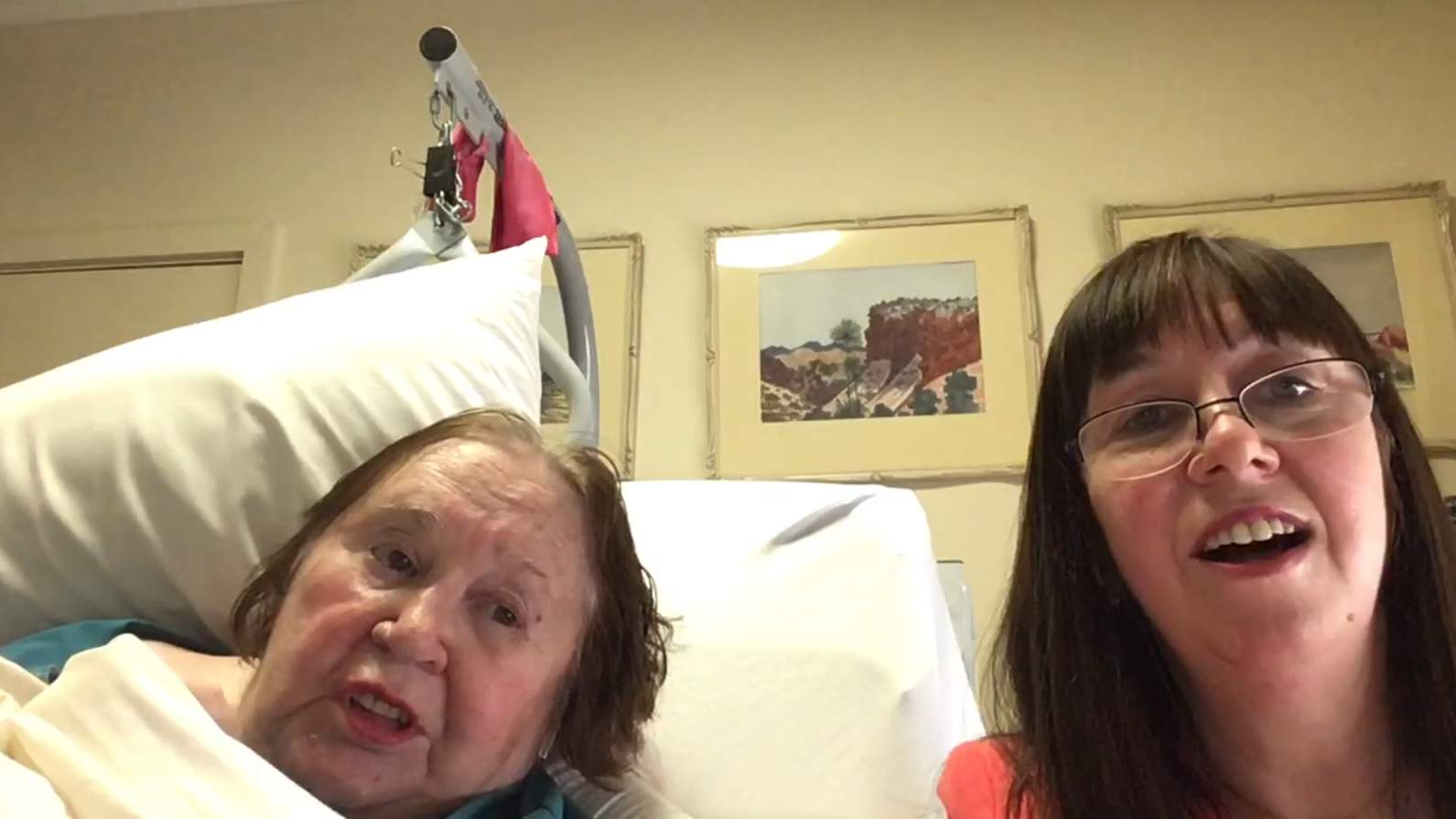 Rosemary sings from her best and Elisabeth sings sitting in a chair next to her.