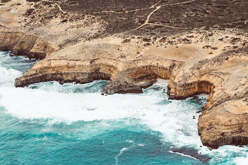 An aerial shot of cliffs next to the ocean.