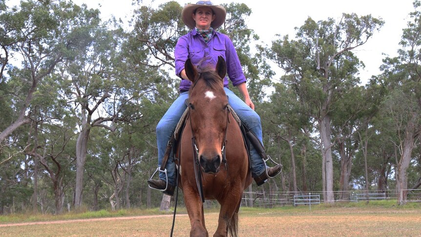 Rebecca Jordan rides towards the camera on a bay horse.
