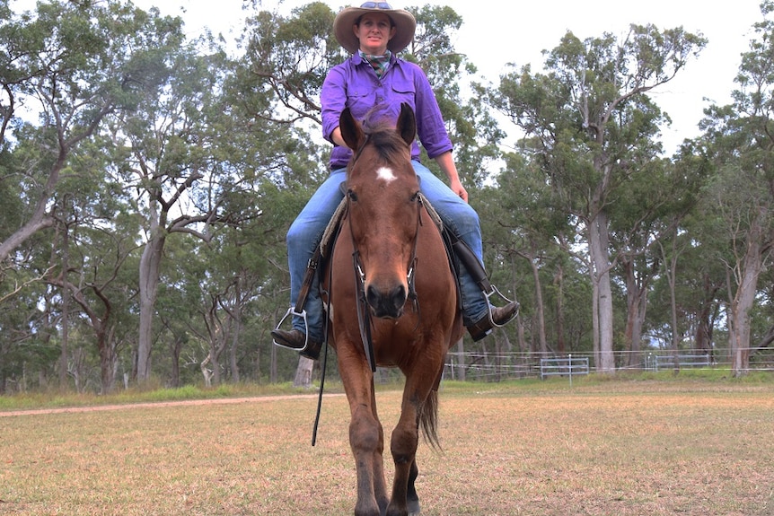 Rebecca Jordan rides towards the camera on a bay horse.