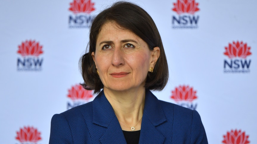 NSW Premier Gladys Berejiklian wearing blue in front of a NSW Government sign at a coronavirus media conference.