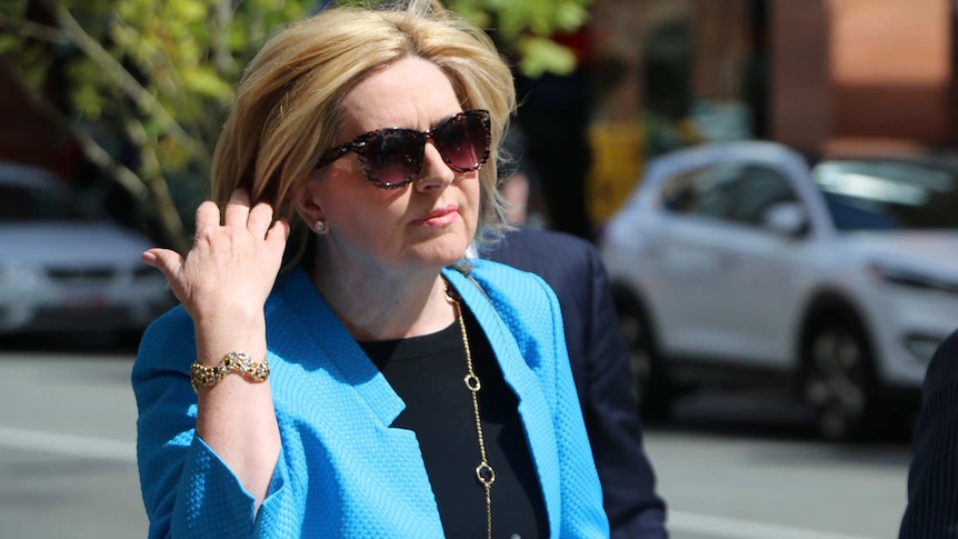 Close-up of Lisa Scaffidi playing with her hair on a city street.