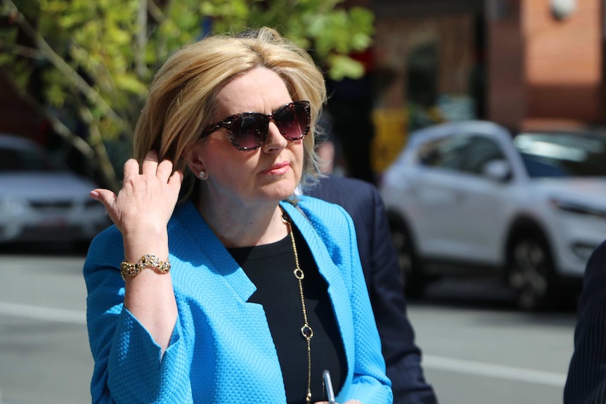 Close-up of Lisa Scaffidi playing with her hair on a city street.