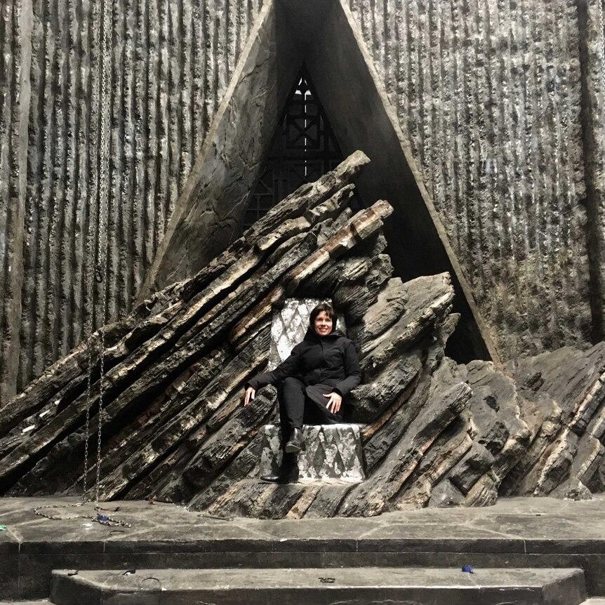Australian production designer Deborah Riley sits on the Dragonstone Throne from Game of Thrones