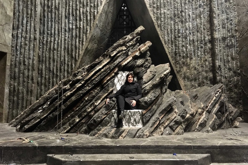 Australian production designer Deborah Riley sits on the Dragonstone Throne from Game of Thrones