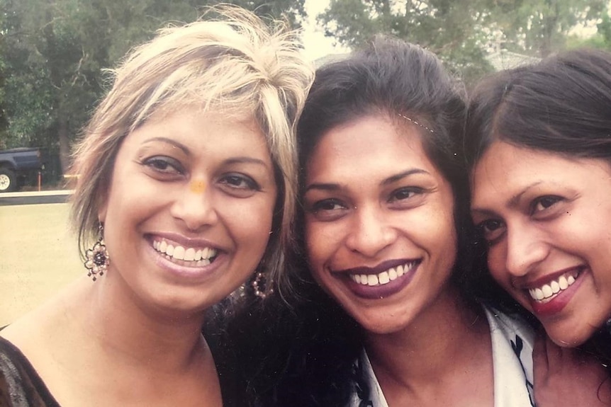 Head shot of three women with heads touching.