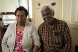 An older couple of Torres Strait Islander appearance sit inside together