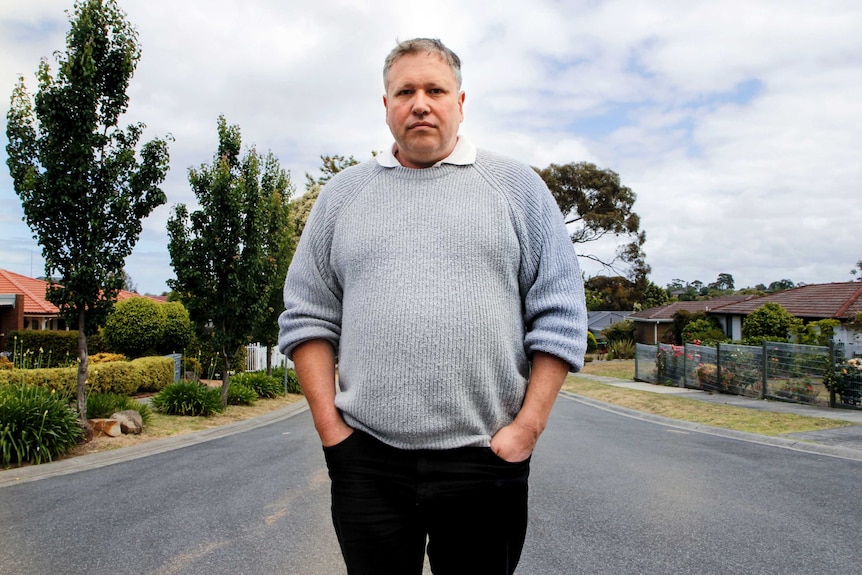 Mark James stands in a suburban street.