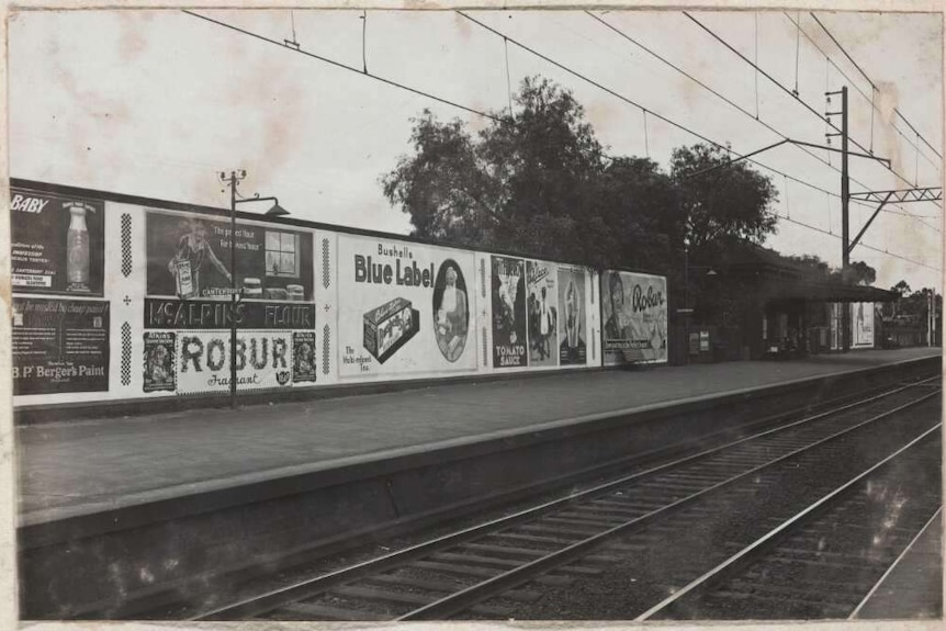 Billboards advertising Bushells and Robur tea at a railway station, Victoria, approximately 1925.
