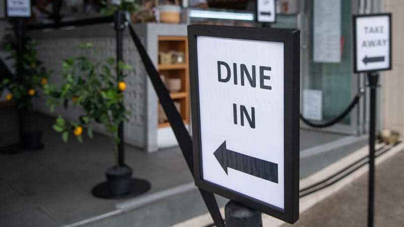 Signs outside a cafe saying dine in.