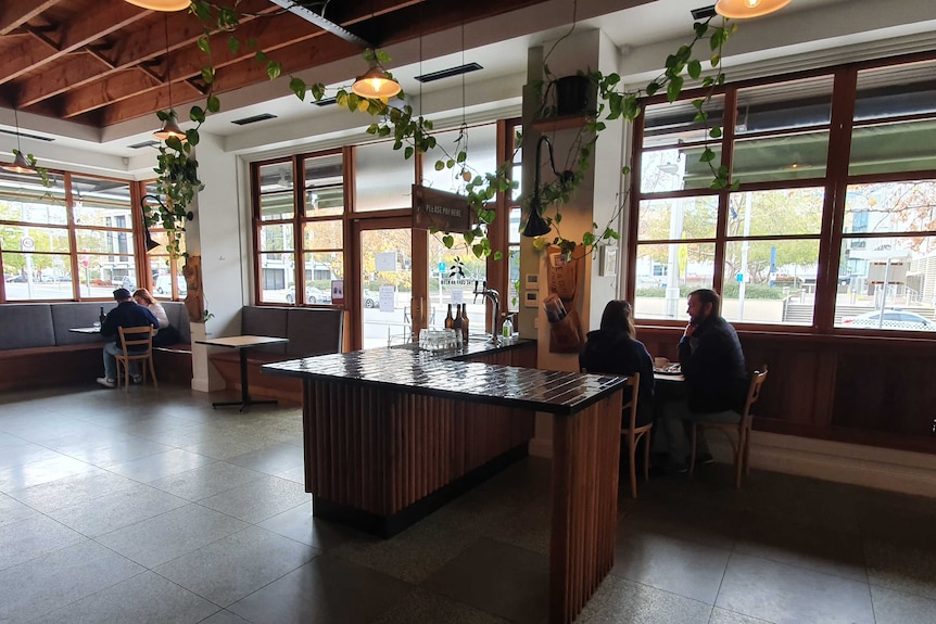 Two couples sit in different parts of the cafe, where only a few tables are available.