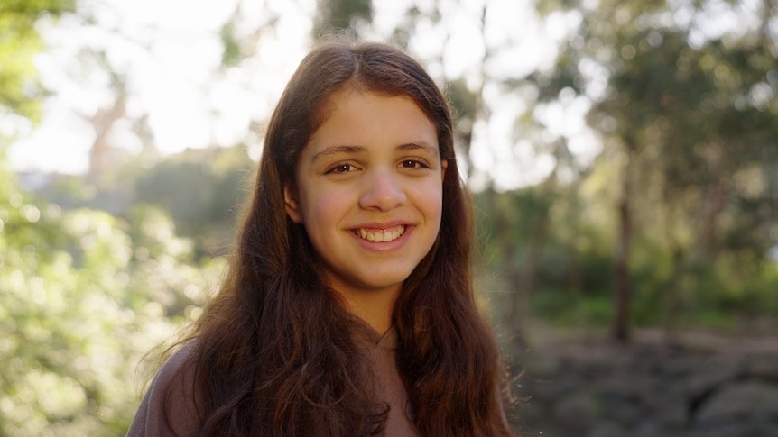 Young girl smiling in bushland