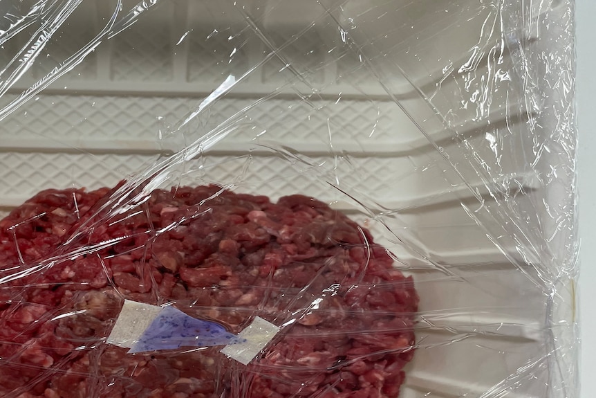 Plastic wrap with blue triangle wraps mince meat. 