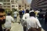 A screen still of mourners fleeing from a funeral in the Syrian city of Homs.