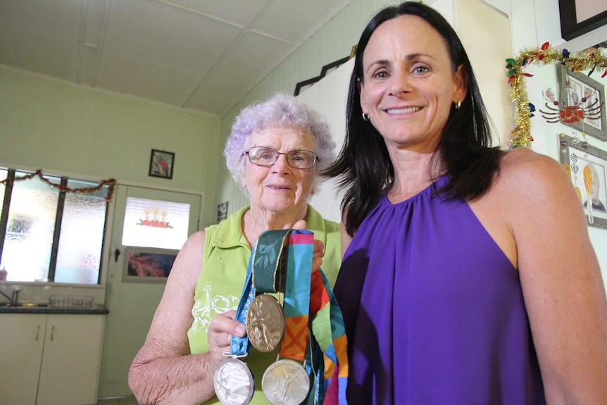Two women hold up medals