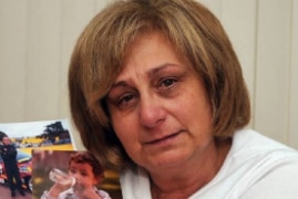 Adriana Buccianti cries and holds images of her son.