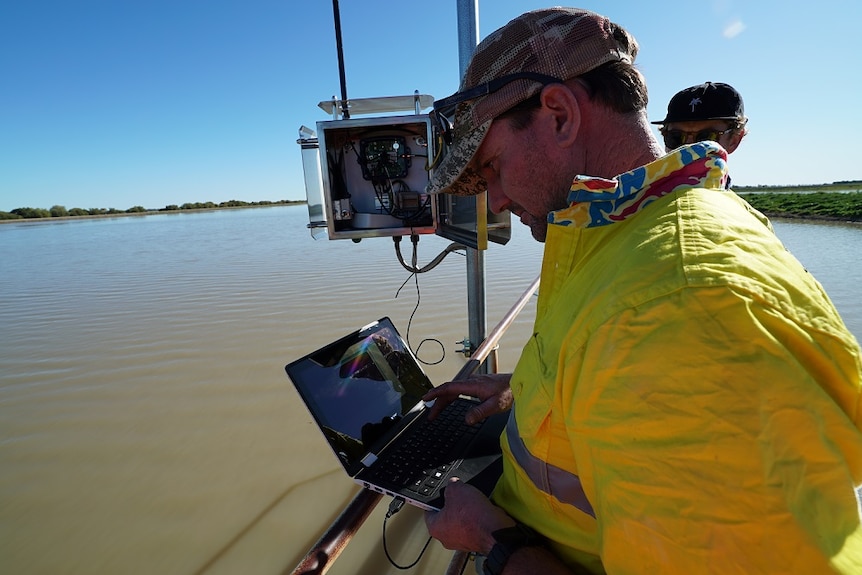 A solar panel and radar device suspended over the water on a flood plain harvesting dam.