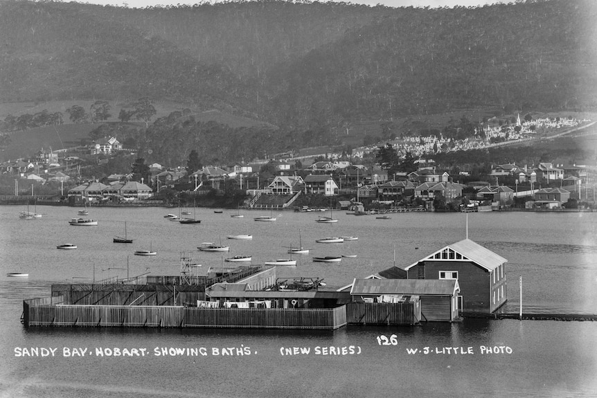 Black and white photograph of Sandy Bay with baths on the River Derwent on the foreshore. 
