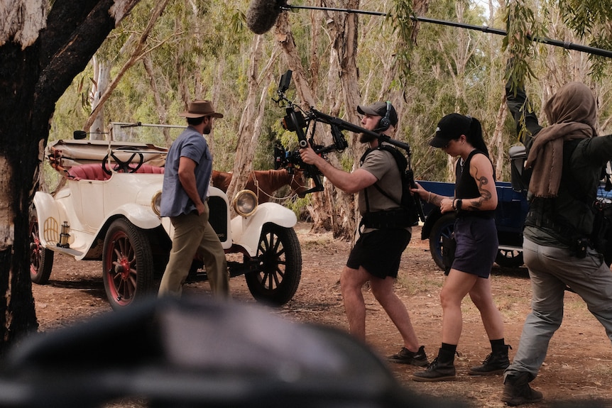 A film crew on set in a bush setting