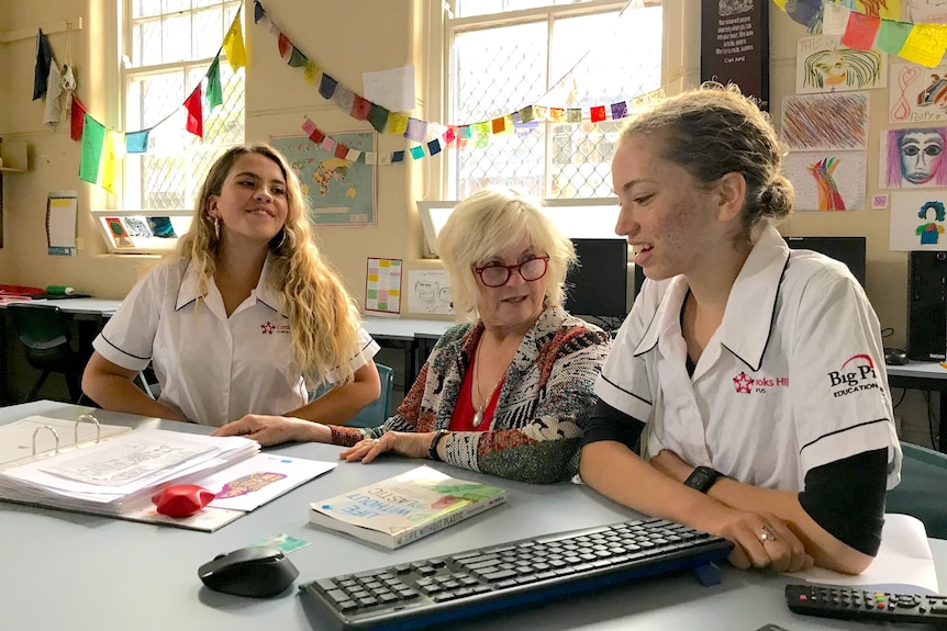 A woman with two students. 