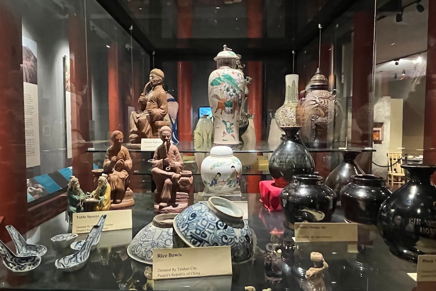 A glass display of historical Chinese artefacts and culture.